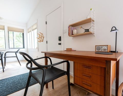 The vintage Danish desk contains notecards, writing pads and basic office supplies. There's a Tivoli Model One radio with Bluetooth, plus a separate portable Bluetooth speaker for audio anywhere.