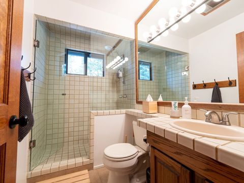 The bathroom features ample room for towels, two built-in wall cabinets for storage and a spacious walk-in shower.