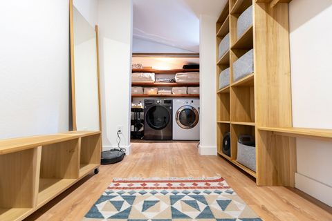 A full-sized front-loading washing machine and dryer are hidden behind accordion doors. All-natural laundry supplies are provided, and there's ample storage above for linens and other items. 