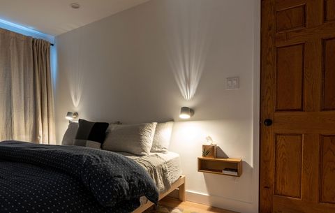 Side bedlights and a blackout linen curtain encourage reading in bed and sleeping in.