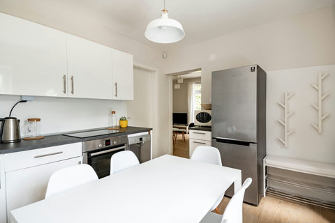 Kitchen with dining area for 6 people, with microwave, and fridge.