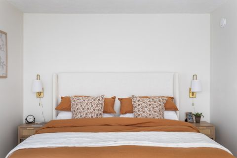 Bedroom has bedside lights and an alarm clock