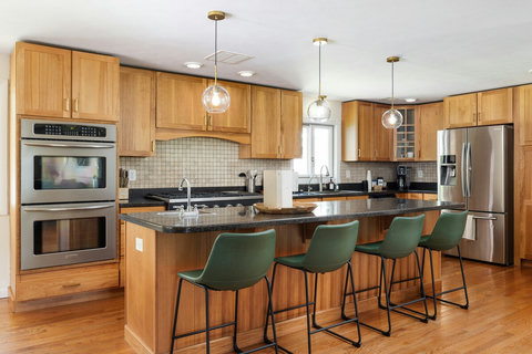 Bright gourmet kitchen with island seating for 4 and stainless appliances