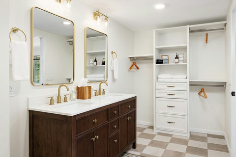 Spacious walk-in closet with double vanity and stylish gold accents