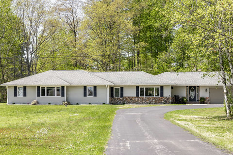 Peaceful ranch home with long driveway, wooded setting, and welcoming curb appeal