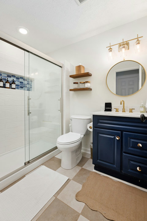 Stylish bath with glass walk-in shower and chic navy vanity