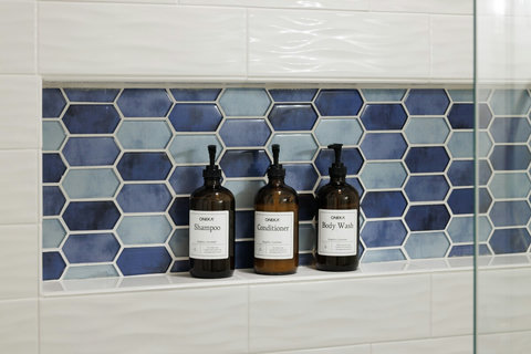 Modern tiled shower with premium bath amenities and a polished spa feel