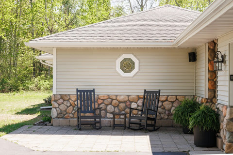 Welcoming front patio with rocking chairs and peaceful wooded views