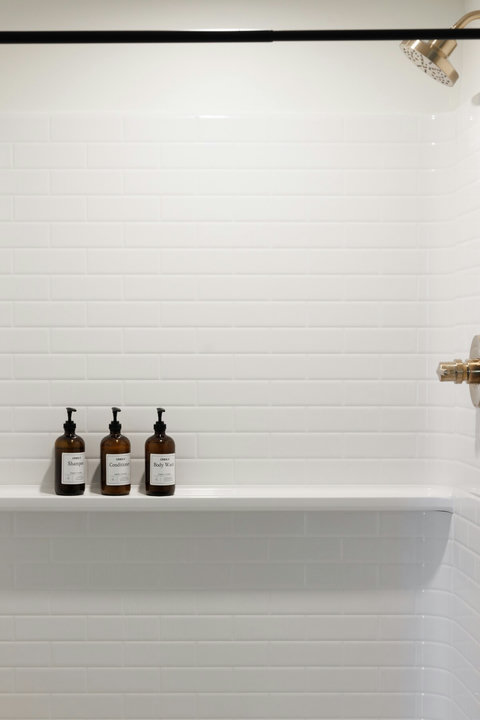 Bright modern shower with subway tile and premium bath amenities