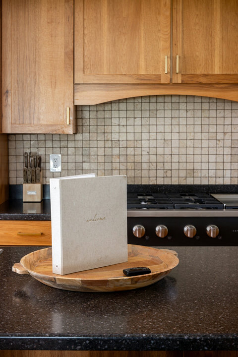 Warm wood kitchen with gas cooktop and spacious stone island