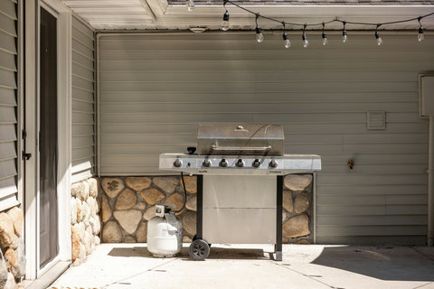 Covered patio with grill and string lights for easy outdoor cookouts
