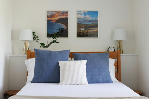 Bright, cozy bedroom with crisp linens, blue accents, and stylish decor