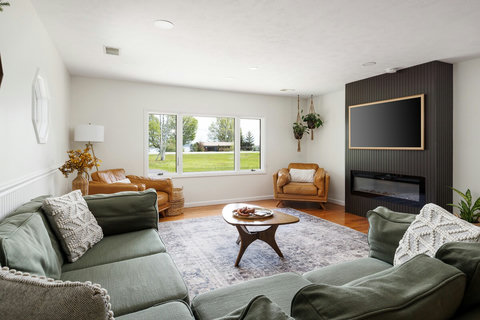 Bright living room with picture windows, fireplace, and cozy seating