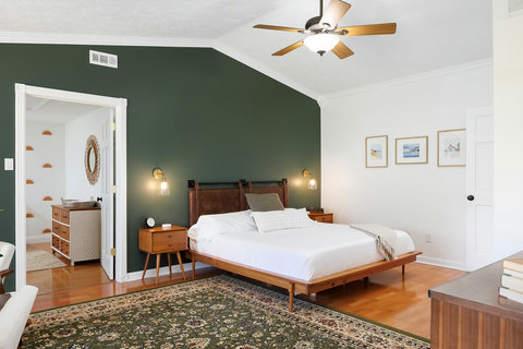 Spacious bedroom retreat with vaulted ceilings and a bold green accent wall
