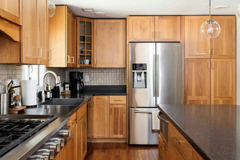 Bright kitchen with wood cabinetry, island, and stainless steel appliances