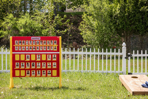 Sunny backyard with lawn games, white fence, and family-friendly fun