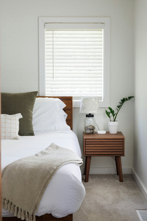 Bright, cozy bedroom with stylish nightstand and natural light
