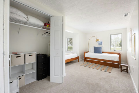 Bright twin bedroom with natural light and convenient closet storage