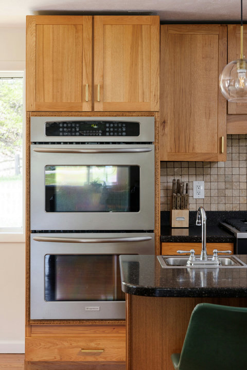 Warm designer kitchen with double ovens and stylish island sink