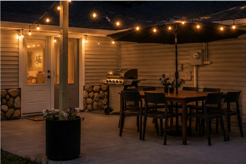 Cozy covered patio with string lights, grill, and outdoor dining