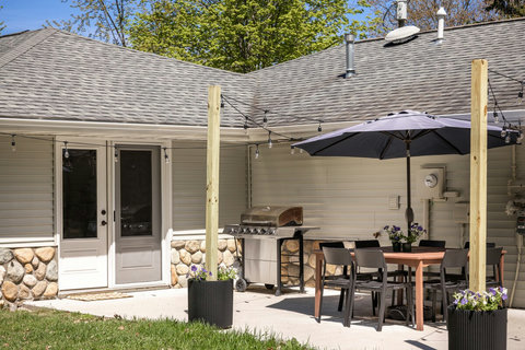Private patio with grill, string lights, and shaded outdoor dining