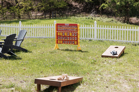 Fenced yard with cornhole, giant Connect Four, and relaxing outdoor seating