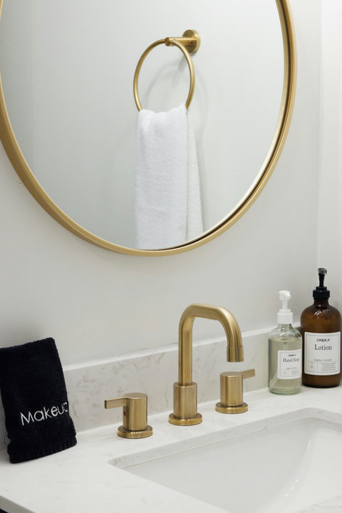 Stylish bathroom vanity with gold fixtures and boutique-style touches