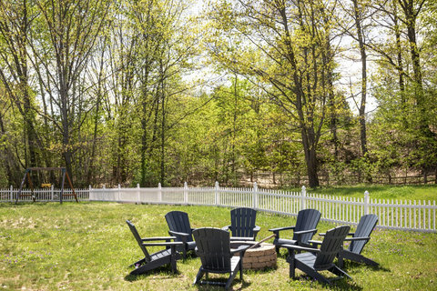 Private fenced backyard with fire pit seating and family-friendly play area