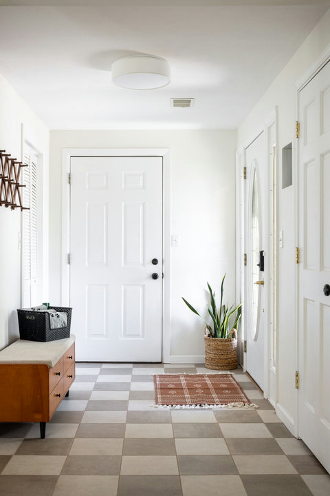 Bright, welcoming entryway with tiled floors, bench seating, and warm decor