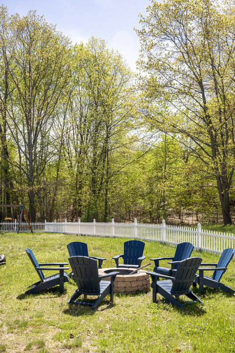 Relax around the backyard fire pit in a peaceful, tree-lined setting