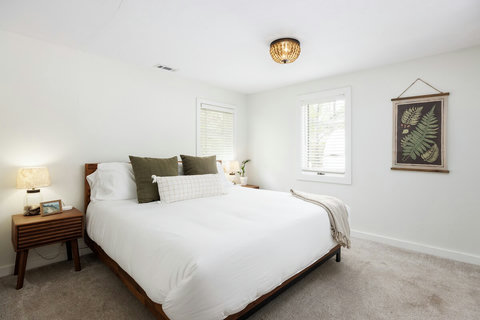 Bright, cozy bedroom with king bed, natural light, and warm modern touches