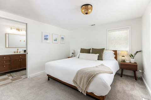 Bright ensuite bedroom with cozy bedding and warm modern touches