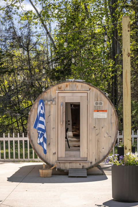 Private barrel sauna with string lights for a cozy backyard retreat