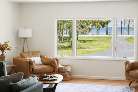 Bright living room with cozy seating and serene water-view window