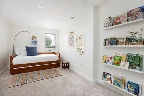Bright kids’ room with cozy daybed and charming built-in book display