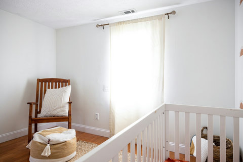 Bright, cozy nursery with crib, rocking chair, and soft natural light