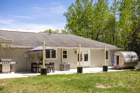 Spacious backyard patio with dining area, grill, and private sauna