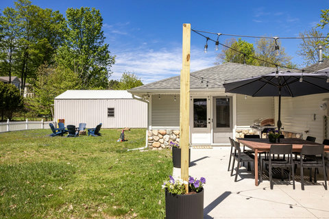 Spacious backyard patio with dining, string lights, and fire pit seating