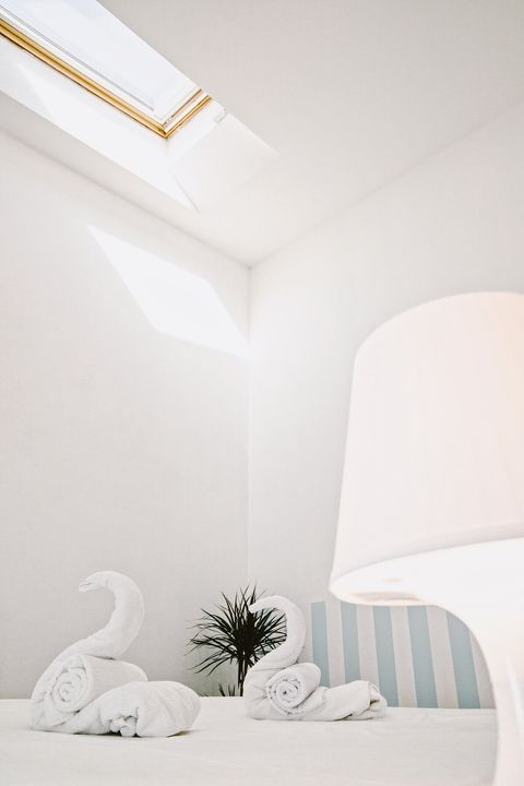 The secondary bedroom features a high ceiling and a practical Velux window that can be opened or closed, complete with a blind shutter to ensure a dark, restful night. The room is also equipped with air conditioning.