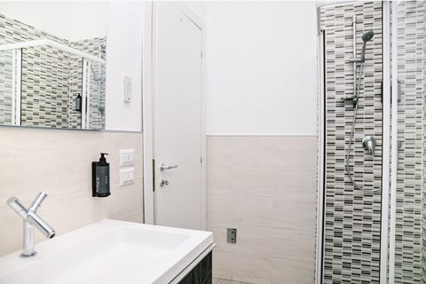 The upper-floor bathroom mirrors the lower floor, featuring a large mirror, elegant sink, bidet, WC, shower, and towel warmer, all complemented by Aqua di Colonia toiletries.