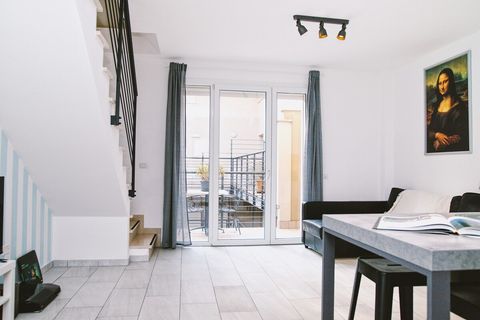 The bright, spacious living room features a 4K TV, turntable, sofa bed, and a dining table for six. A terrace at the far end, overlooking the courtyard, includes a marble table for additional dining.