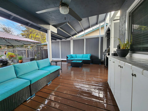 Backyard deck - ceiling fan with light, barbecue grill, outdoor couches.