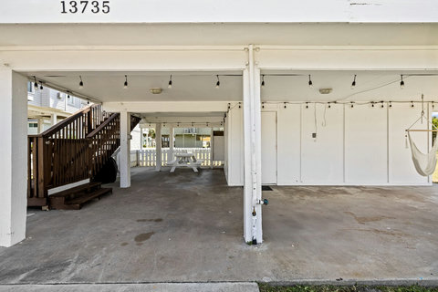 Downstairs patio area with picnic table, charcoal grill, and hammock chairs.