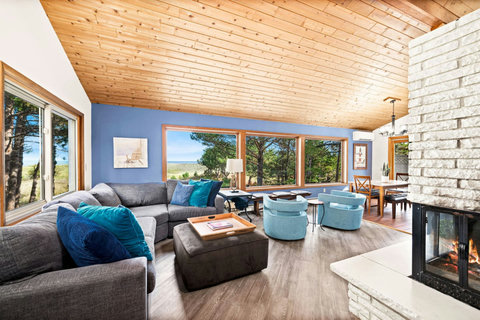 Overside picture windows with lake view and cozy fireplace in the living room