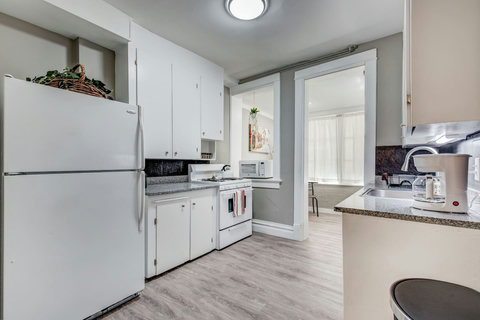 Fully-stocked kitchen with a refrigerator, stove, oven, microwave, tea kettle, and coffee maker