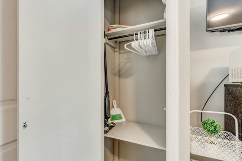 Closet space with hangers and cleaning equipment, steamer for clothing