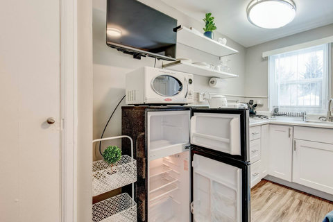 Mid-sized refrigerator and freezer, shelving for storage next to the refrigerator
