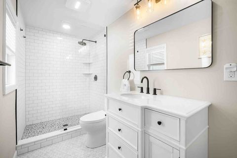 En-suite master bathroom with walk-in shower and pebble tile floor. 