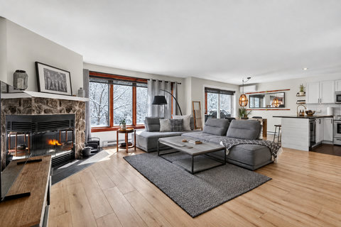 Cozy fireplace, bright open living space, and stylish kitchen seating