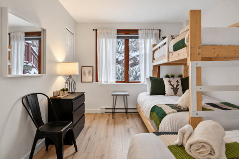 Cozy bunk room with snowy views, natural light, and stylish touches